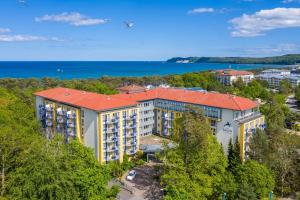 an aerial view of a building with trees and the water at IFA Rügen Hotel & Ferienpark in Binz
