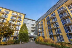 a yellow building with a tree in front of it at IFA Rügen Hotel & Ferienpark in Binz +116 photos