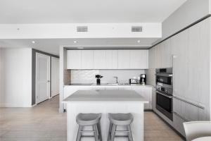 a kitchen with a white counter and two bar stools at Stylish 3BR Resort Condo with Beach Access, Two Infinity Pools and Private Balcony -NO RESORT & NO PARKING FEES, CHECK DETAILS in Hollywood