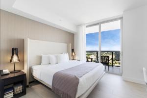 a bedroom with a large bed and a large window at Stylish 3BR Resort Condo with Beach Access, Two Infinity Pools and Private Balcony -NO RESORT & NO PARKING FEES, CHECK DETAILS in Hollywood