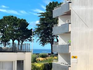 d'un bâtiment avec des balcons et l'océan en arrière-plan. dans l'établissement Ty Corniche - 50m de la plage, à Bénodet