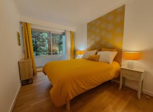 une chambre avec un lit jaune et une fenêtre dans l'établissement Ty Corniche - 50m de la plage, à Bénodet