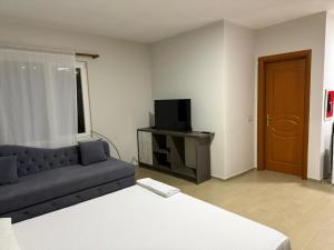 Una sala de estar con un sofá y un televisor en Rooftop Gallery Hostel, en Tirana 11 fotos más