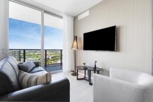a living room with a couch and a flat screen tv at Stylish 3BR Resort Condo with Beach Access, Two Infinity Pools and Private Balcony -NO RESORT & NO PARKING FEES, CHECK DETAILS in Hollywood +57 photos