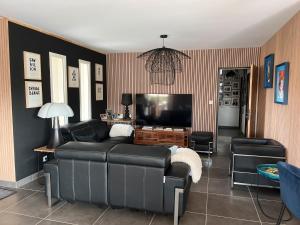 een woonkamer met een bank en een flatscreen-tv bij Villa Rube in Coustellet