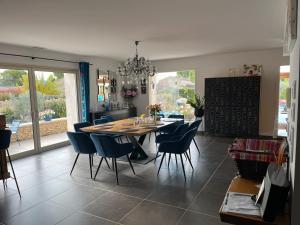een eetkamer met een tafel en blauwe stoelen bij Villa Rube in Coustellet