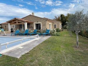 een huis met blauwe stoelen in de tuin bij Villa Rube in Coustellet