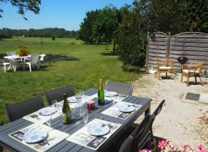 ein Picknicktisch mit Weinflaschen und Gläsern darauf in der Unterkunft Gite Le Fournil in Saint-Hilaire-la-Palud