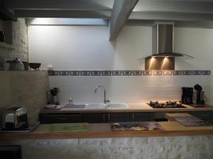 eine Küche mit Spüle und Herd in der Unterkunft Gite Le Fournil in Saint-Hilaire-la-Palud + 6 Fotos