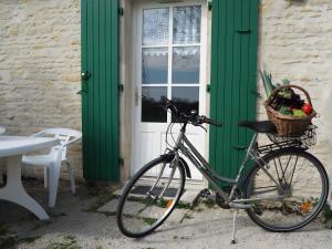 ein Fahrrad parkt vor einem Haus mit grüner Tür in der Unterkunft Gite Le Fournil in Saint-Hilaire-la-Palud