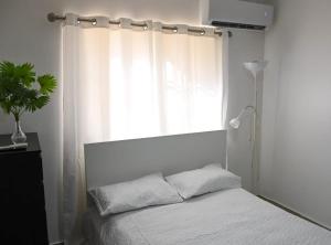a bedroom with a white bed and a window at Bellomar I Exclusive Juan Dolio Playa Hemingway in Juan Dolio