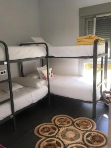 a room with three bunk beds and a rug at Villa Rompido in El Rompido