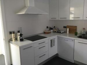 a white kitchen with white cabinets and a sink at Villa Rompido in El Rompido