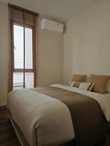 ein Schlafzimmer mit großem Bett und Fenster in der Unterkunft Swan, Private Pool Villa Bangsaen in Ban Thai Don (1)