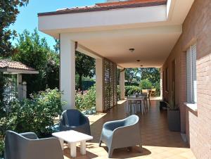 a patio with chairs and tables and a building at La Principessa Nera B&B in Ostra