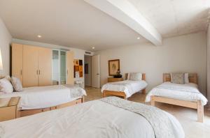 a bedroom with two beds and a room with two tables at Magia beachside condos in Playa del Carmen +108 photos