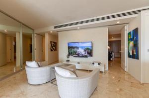 a living room with a couch and chairs and a table at Magia beachside condos in Playa del Carmen