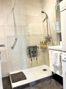 une douche avec une porte vitrée dans une salle de bain dans l'établissement Appartement neuf à boulogne à 3 mins à pieds du métro, à Boulogne-Billancourt