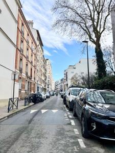 une rue avec des voitures garées sur le bord de la route dans l'établissement Appartement neuf à boulogne à 3 mins à pieds du métro, à Boulogne-Billancourt