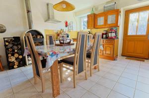 eine Küche mit einem Esstisch und Stühlen in der Unterkunft Gîte de NOE au Ray-pic in Péreyres