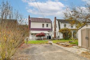un groupe de maisons avec une allée et un garage dans l'établissement Art Lovers Paradise! Cozy Cottage in Huntington, à Huntington