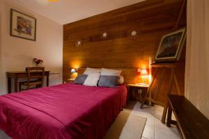 ein Schlafzimmer mit einem großen Bett mit einer roten Decke in der Unterkunft Gîte de NOE au Ray-pic in Péreyres