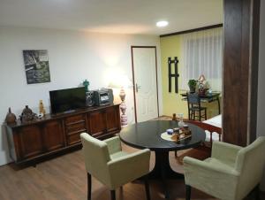 a living room with a table and chairs and a television at Z A M A K Vila in Vranje