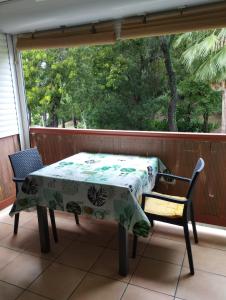 a table and chairs on a porch with a window at Studio Le Balisier in Caritan