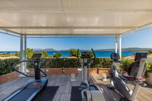 a gym with cardio equipment on the roof of a house at The Pelican Beach Resort & SPA - Adults Only in Olbia