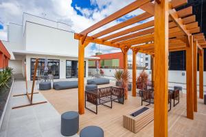 un patio extérieur avec une pergola en bois dans l'établissement Edificio MUV Yogha, à Curitiba