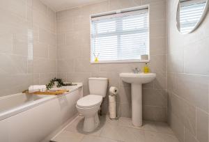 une salle de bains blanche avec toilettes et lavabo dans l'établissement Modern Comfort, Free Parking, Netflix & Disney plus in every Bedroom and Living Room, à Shephall 30 autres photos