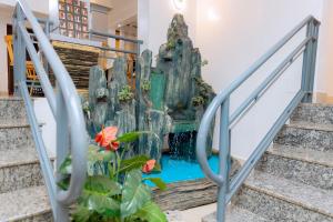 a waterfall in the lobby of a hotel with stairs at OMX Hotel Kimihurura in Kigali