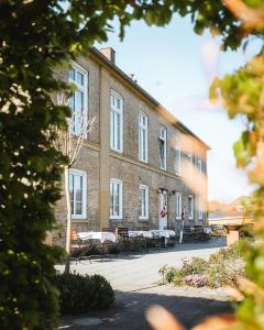 a building with tables and chairs in front of it at Lindegaarden Kollund in Kruså