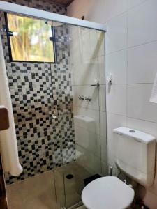 ein Badezimmer mit Toilette und Glasdusche in der Unterkunft Charmoso Chalé container em Piracaia, in Piracaia