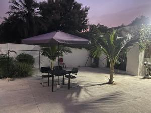 斯基灵角Marsu hotel的一个带桌子和遮阳伞的庭院和棕榈树