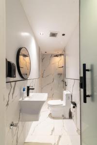 un bagno bianco con lavandino e WC di شاليهات روح نجد a Al ‘Ammārīyah