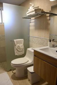 a bathroom with a white toilet and a sink at Bellomar I Exclusive Juan Dolio Playa Hemingway in Juan Dolio