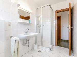 a white bathroom with a sink and a shower at Brixen Alpin Living Top 8 in Brixen im Thale +24 photos