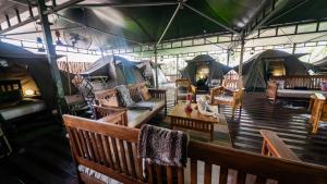 a room with a bunch of chairs and tents at The Tree Top Village Urban Glamping in St Lucia