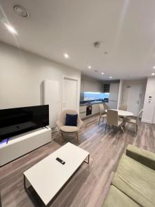 a living room with a tv and a couch and a table at 2 Bedroom Brentford in Kew Bridge