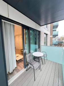 a patio with a table and chairs on a balcony at 2 Bedroom Brentford in Kew Bridge