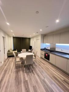 a kitchen and a dining room with a table and chairs at 2 Bedroom Brentford in Kew Bridge