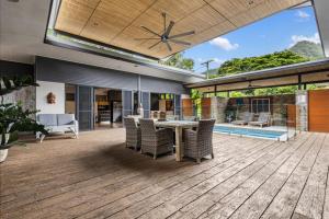 Balinese Style Villa With Bionized Pool في Bayview Heights: فناء مفتوح مع طاولة وكراسي على السطح