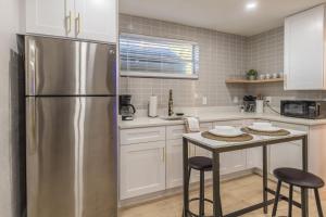 a kitchen with a stainless steel refrigerator and a table at CUTE and COZY studio w jacuzzi in Orlando +23 photos