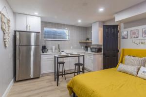 a bedroom with a bed and a kitchen with a refrigerator at CUTE and COZY studio w jacuzzi in Orlando
