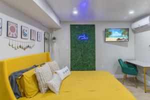 a bedroom with a yellow bed and a desk at CUTE and COZY studio w jacuzzi in Orlando
