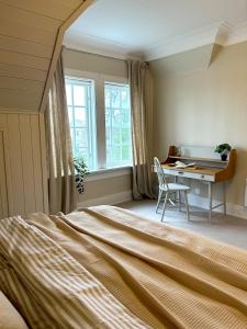 a bedroom with a bed and a desk and a table at Historic villa with large garden in Stord