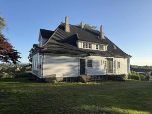 an old house sitting on top of a field at Historic villa with large garden in Stord