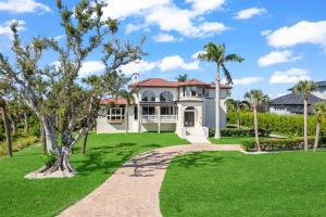 YbelSeashell Paradise on Sanibel Island的一座拥有绿色草坪和棕榈树的房子