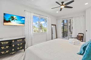 YbelSeashell Paradise on Sanibel Island的一间卧室，里面有一张床和一个吊扇 更多52张照片